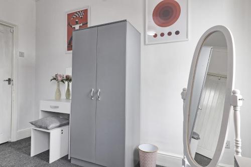 a bathroom with a white cabinet and a mirror at Beautiful Spacious four bedroom house with parking for 2 cars, 5 minute walk to southend station in Southend-on-Sea