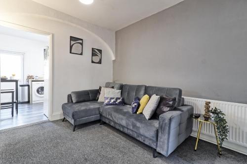 a living room with a couch and a table at Beautiful Spacious four bedroom house with parking for 2 cars, 5 minute walk to southend station in Southend-on-Sea