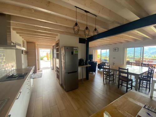 Il dispose d'une cuisine et d'un salon avec une table et un réfrigérateur. dans l'établissement Gîte spacieux 10 pers à Vagney - Sauna, jeux, proche Gérardmer - FR-1-589-400, à Vagney