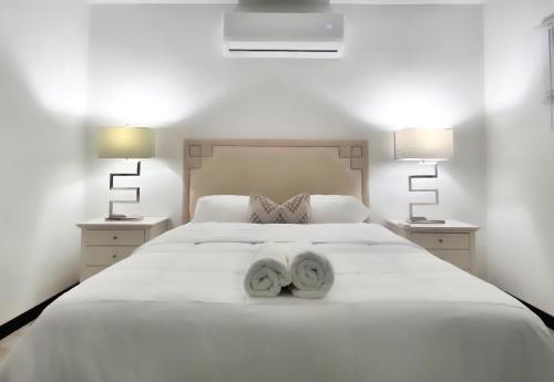Un dormitorio con una cama blanca con toallas. en Secret View en Isabela