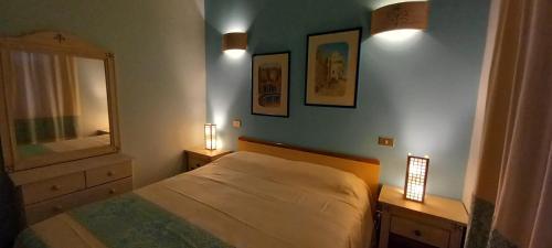 1 dormitorio con cama, espejo y luces en Casa Erbì en Torre Dei Corsari