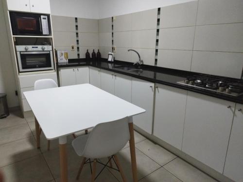 uma cozinha com uma mesa branca e uma bancada branca em Excelente ubicación!!! em Montevidéu