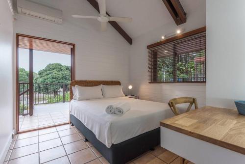 Un dormitorio con una cama y un balcón. en 10 Wharf Street - a tropical family home, en Port Douglas