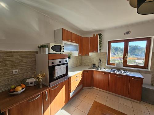 cocina grande con armarios de madera y ventana en Apartments with a parking space Lun, Pag - 21905, en Lun