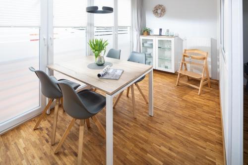 ein Esszimmer mit einem Holztisch und Stühlen in der Unterkunft Sonnendeck 14 in Norderney
