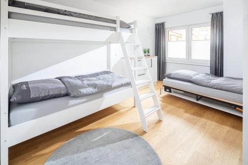 ノルダーナイにあるWolkenlosのベッドルーム1室(二段ベッド2台、はしご付)