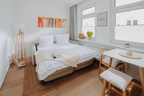 Dormitorio pequeño con cama y mesa en Villa Fresena Bude 9, en Norderney