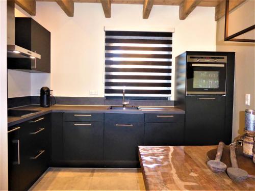 a kitchen with black cabinets and a sink and a window at Chalet Diamond Winterberg 6 Person near by Bikepark Wifi in Winterberg