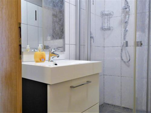 Un baño blanco con lavabo y ducha. en Cityview Winterberg Ferienwohnung in der City, en Winterberg