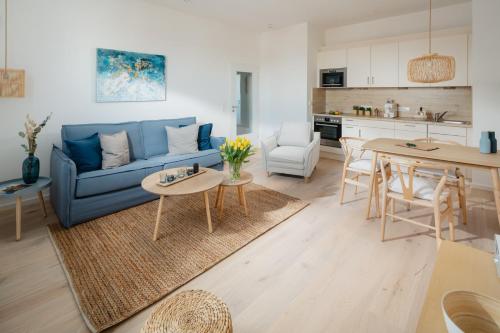ein Wohnzimmer mit einer blauen Couch und einem Tisch in der Unterkunft Kapkieker in Norderney