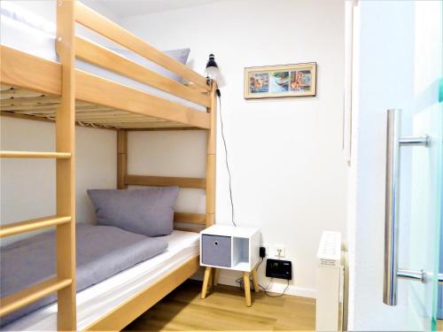 Ce lit superposé se trouve dans une petite chambre dotée d'un bureau. dans l'établissement AwayHome Winterberg Ferienwohnung Pool Sauna 5 Pers Wifi near Bikepark Switch Terrasse, à Winterberg