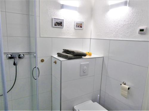 une salle de bain blanche avec douche et toilettes dans l'établissement AwayHome Winterberg Ferienwohnung Pool Sauna 5 Pers Wifi near Bikepark Switch Terrasse, à Winterberg