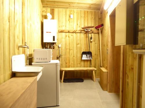 baño con paredes de madera, fregadero y nevera en Chalet Luxury Winterberg Modern Wifi 3xSchlafzimmer near by Bikepark, en Winterberg