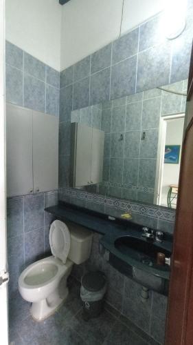 een badkamer met een toilet, een wastafel en een spiegel bij Hotel Miami en Melgar in Melgar