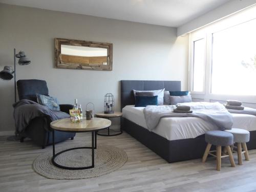 a bedroom with a bed and a table and a couch at Mountain Suite Winterberg Ferienwohnung Pool Sauna Hund 4 Pers Wifi near Ski Lift in Winterberg