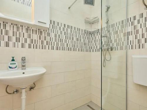 a white bathroom with a sink and a shower at Apartments with a parking space Babino Polje, Mljet - 22321 in Babino Polje