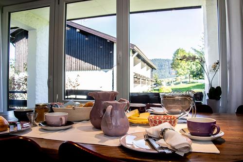 une table avec des assiettes et des vases au-dessus dans l'établissement GreenHill 4 - mit Privatsauna, à Oberstaufen