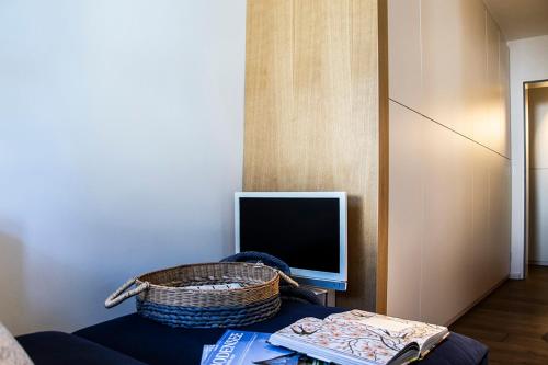 - un salon avec une télévision et un panier sur une table dans l'établissement GreenHill 4 - mit Privatsauna, à Oberstaufen
