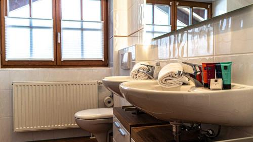 uma casa de banho com 2 lavatórios e um WC em Seelenruhe em Oberstaufen