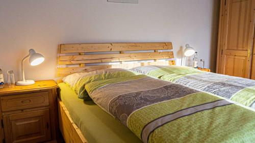 - une chambre avec un lit avec une tête de lit en bois et deux lampes dans l'établissement FEWO Marion, à Oberstaufen