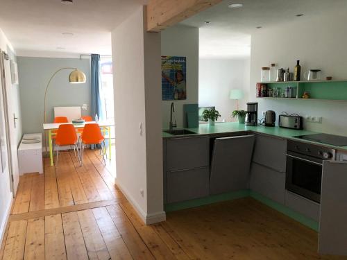 - une cuisine avec des comptoirs verts et des chaises orange dans l'établissement Rosinas - Christian, à Oberstaufen