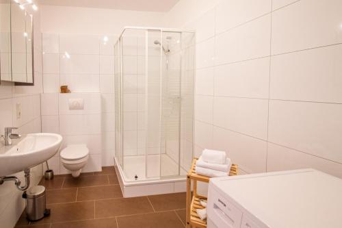 La salle de bains est pourvue d'une douche, de toilettes et d'un lavabo. dans l'établissement Up Warft - West, à Krummhörn