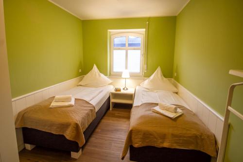 two beds in a room with green walls at Int Hörn 2 EG in Krummhörn