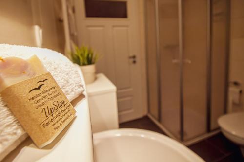 a bathroom with a toilet and a sign on a towel at Int Hörn 4 OG in Krummhörn