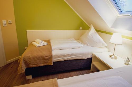 Pokój z łóżkiem, lampką i zielonymi ścianami w obiekcie Int Hörn 7 OG w mieście Krummhörn
