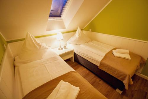 two beds in a small room with a window at Int Hörn 8 OG in Krummhörn