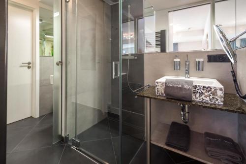 y baño con lavabo y ducha. en Schippers Huus 04 - Bismarckloft, en Norderney