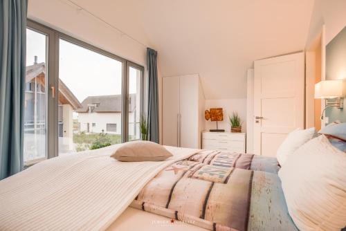 um quarto com uma cama grande e uma janela grande em Willem und Konsorten - Hafenflair em Heiligenhafen