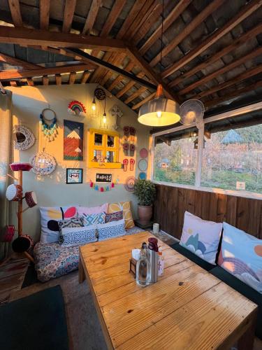 a living room with a wooden table and a couch at Parvatah in Bīr