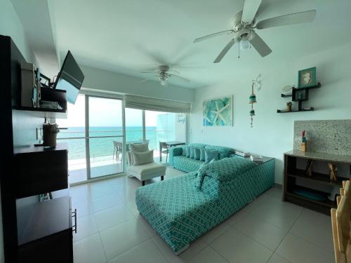 ein Wohnzimmer mit Sofa, TV und Meerblick in der Unterkunft Resort Playa Azul 3 Dormitorios in Tonsupa