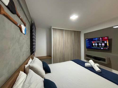 マセイオにあるApartamentos 250m da Orla -Edifício Nugali- Castelo B Temporadaのベッド1台、薄型テレビが備わるホテルルームです。