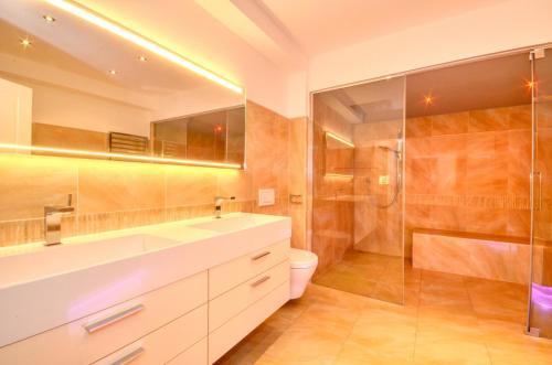 a bathroom with a sink and a toilet and a shower at Eichenhof Top 2 - by Alpen Apartments in Zell am See