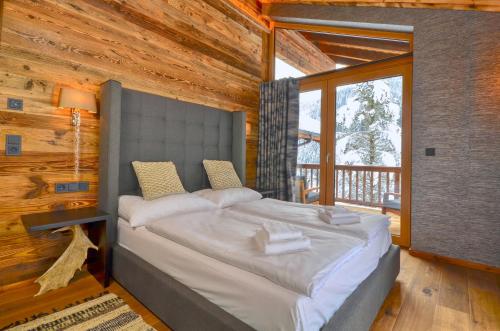 1 dormitorio con 1 cama grande en una cabaña de madera en Chalet Schmitten - by Alpen Apartments en Zell am See