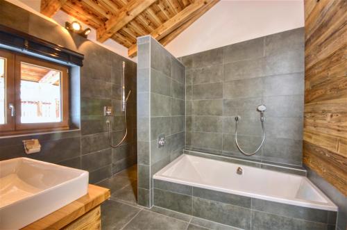 łazienka z wanną i umywalką w obiekcie Chalet Schmitten - by Alpen Apartments w mieście Zell am See