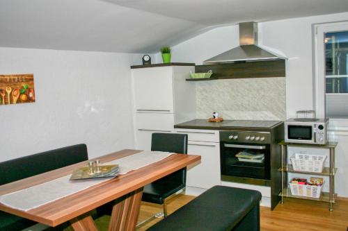 a kitchen with a table and a stove top oven at Apartment Birke 1 - by Alpen Apartments in Bad Gastein