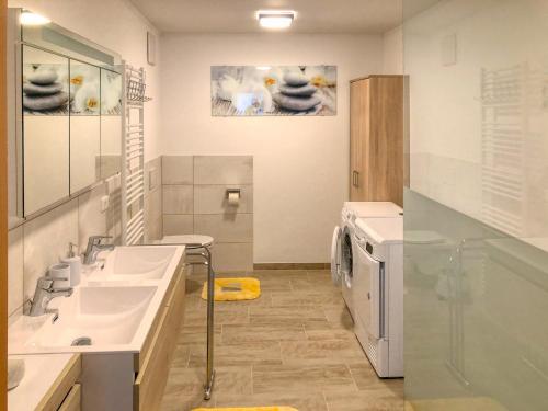 a bathroom with two sinks and a washing machine at Apartment Birke 2 - by Alpen Apartments in Bad Gastein