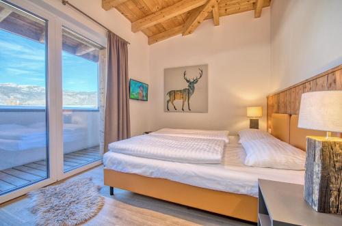 a bedroom with a bed with a deer on the wall at Penthouse Ski & Golf - by Alpen Apartments in Zell am See