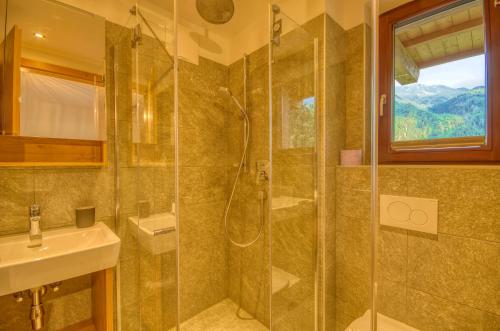 a bathroom with a shower and a sink at Ski-in Ski-out Chalet Maiskogel 17A - by Alpen Apartments in Kaprun