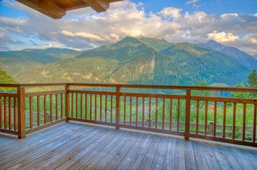 a wooden balcony with a view of mountains at Ski-in Ski-out Chalet Maiskogel 17A - by Alpen Apartments in Kaprun