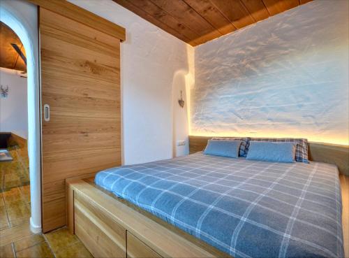 a bedroom with a blue bed in a room at Haus Kitzsteinhorn 7 - by Alpen Apartments in Kaprun