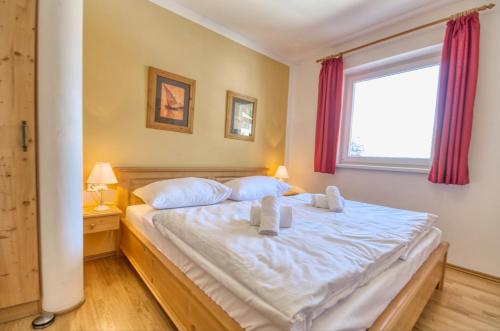 - une chambre avec un lit doté de draps blancs et une fenêtre dans l'établissement Apartment Dunn - by Alpen Apartments, à Bad Gastein