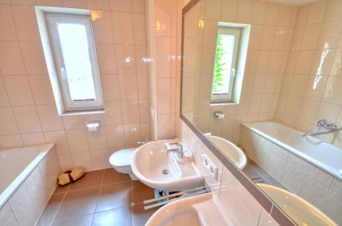 La salle de bains est pourvue d'un lavabo, de toilettes et d'une baignoire. dans l'établissement Apartment Dunn - by Alpen Apartments, à Bad Gastein