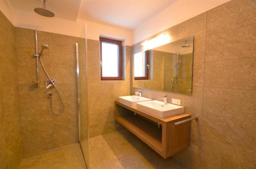 uma casa de banho com um lavatório e um chuveiro em Ski-in Ski-out Chalet Maiskogel 13A - by Alpen Apartments em Kaprun