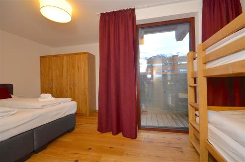 a bedroom with two beds and a large window at Ski-in Ski-out Chalet Maiskogel 13A - by Alpen Apartments in Kaprun
