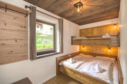 a small bedroom with a bed and a window at Haus Kitzsteinhorn 6 - by Alpen Apartments in Kaprun