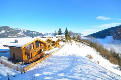 a log cabin in the snow with a mountain at Ski-in Ski-out Chalet Maiskogel 13A - by Alpen Apartments in Kaprun